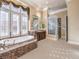 Spa-like bathroom with soaking tub, walk-in shower, and large windows at 3 Palmbrook Ln, Henderson, NV 89052