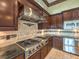 Spacious kitchen with dark wood cabinets, granite countertops, and stainless steel appliances at 3 Palmbrook Ln, Henderson, NV 89052