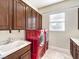 Laundry room with red appliances and wood cabinets at 3 Palmbrook Ln, Henderson, NV 89052