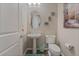 Small bathroom with pedestal sink, toilet, and oval mirror at 421 Point Sur Ave, Las Vegas, NV 89138