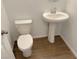 Clean bathroom with pedestal sink, toilet and brown tile floor at 4771 Illustria Ave, Las Vegas, NV 89141