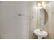 Small powder room with pedestal sink and oval mirror at 5064 Sacred Datura Ave, Las Vegas, NV 89139