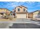 Two-story house with beige exterior, attached garage, and landscaping at 5332 Iron Crossing Ave, Las Vegas, NV 89131