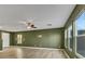 Spacious living room with light wood floors, green walls, and ceiling fan at 5332 Iron Crossing Ave, Las Vegas, NV 89131