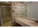 Bathroom featuring unique stone wall and tub with shower at 4709 W Alpine Pl, Las Vegas, NV 89107