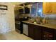 Compact kitchen with stone walls, stainless steel appliances, and granite countertops at 4709 W Alpine Pl, Las Vegas, NV 89107