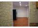 Open-concept layout with stone walls, hardwood flooring, and a black refrigerator at 4709 W Alpine Pl, Las Vegas, NV 89107