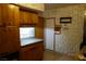 Retro kitchen with stone walls, wooden cabinetry, and granite countertops at 4709 W Alpine Pl, Las Vegas, NV 89107