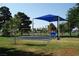 Community playground with a blue shade structure covering play equipment surrounded by a grassy area at 4709 W Alpine Pl, Las Vegas, NV 89107