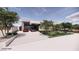 Modern home with a glass garage door, two parked cars, and landscaped yard, surrounded by mature trees on a sunny day at 495 Cityview Ridge Dr, Henderson, NV 89012