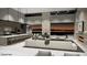 Open-concept living area with a modern kitchen, ample seating, fireplace, and large windows showcasing a vibrant cityscape at 495 Cityview Ridge Dr, Henderson, NV 89012