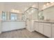 Bright bathroom featuring dual vanities, large mirrors, and a glass-enclosed shower at 104 Barkset Way, Henderson, NV 89011