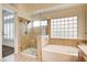 Elegant bathroom with a glass shower, soaking tub, and dual sinks at 1708 Jack Rabbit Way, Las Vegas, NV 89128