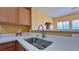 Well-lit kitchen with a stainless steel sink, neutral countertops, and wood cabinets at 2020 Rancho Lake Drive Dr # 205, Las Vegas, NV 89108