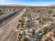 Aerial view of a house, pool, and surrounding neighborhood with highway in background at 4767 Del Sueno Dr, Las Vegas, NV 89120