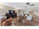 Living room with brown sofas, tile floor, and large TV at 4767 Del Sueno Dr, Las Vegas, NV 89120