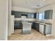 Galley kitchen with island, gray cabinets, and tile floor at 5455 Hasley Canyon Ave, Las Vegas, NV 89139