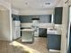 Galley kitchen with island, gray cabinets, and tile floor at 5455 Hasley Canyon Ave, Las Vegas, NV 89139