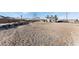 Expansive gravel backyard, offering ample space and a view of the property's rear elevation at 664 Spring Rd, Indian Springs, NV 89018