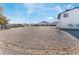 Large, mostly gravel backyard with a house partially visible in the background at 664 Spring Rd, Indian Springs, NV 89018