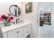 Clean bathroom, white vanity, and view into kitchen area at 664 Spring Rd, Indian Springs, NV 89018