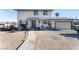 Two-story house with a gray door, attached garage, and spacious yard at 664 Spring Rd, Indian Springs, NV 89018