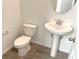 Powder room with pedestal sink, toilet, and tile flooring at 9922 Angel Valley Dr, Las Vegas, NV 89178