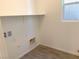 Bright laundry room with washer and dryer hookups, overhead shelving, and tile flooring at 9922 Angel Valley Dr, Las Vegas, NV 89178