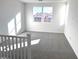 Bright loft area with two windows, grey carpet, and white railing at 9922 Angel Valley Dr, Las Vegas, NV 89178