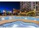 Night view of luxurious pool with palm trees and buildings in the background and spas at 222 Karen Ave # 3907, Las Vegas, NV 89109