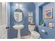 Stylish powder room with blue walls, pedestal sink, and decorative accents at 11009 Pentland Downs St, Las Vegas, NV 89141