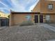 Front view of a light brown stucco duplex with a small front yard and walkway at 6311 W Washington Ave, Las Vegas, NV 89107