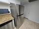 Stainless steel refrigerator in a kitchen with granite countertops at 6311 W Washington Ave, Las Vegas, NV 89107