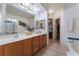 Bright bathroom featuring double sinks, a large mirror, and a walk-in shower at 10710 Destination Ln # 201, Las Vegas, NV 89144