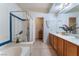 Bathroom view featuring a shower, soaking tub, and double sink vanity with wood cabinets at 10710 Destination Ln # 201, Las Vegas, NV 89144