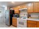 A compact kitchen featuring a white oven, and wood cabinets at 10710 Destination Ln # 201, Las Vegas, NV 89144