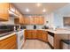 Well-lit kitchen with tile flooring, light countertops, wood cabinets, and white appliances at 10710 Destination Ln # 201, Las Vegas, NV 89144