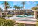 Beautiful pool area with palm trees and community buildings in the background at 10710 Destination Ln # 201, Las Vegas, NV 89144