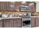 Stainless steel appliances and granite countertops in this modern kitchen at 145 Langley Hill Ave, Henderson, NV 89002