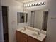 Bathroom with double sinks, large mirror, and light wood cabinets at 3367 Villa Fiori Ave, Las Vegas, NV 89141