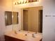 Bathroom boasts double sinks, a large mirror, and light wood cabinets at 3367 Villa Fiori Ave, Las Vegas, NV 89141