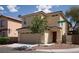 Tan two-story house with red door and attached garage at 3367 Villa Fiori Ave, Las Vegas, NV 89141