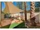 Backyard with covered patio, sandbox, and palm trees at 3464 Trilogy Dr, Las Vegas, NV 89108