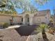 Front entryway of a house with an arched entry, tile roof, and desert landscaping at 11037 Hawk Valley Ave, Las Vegas, NV 89134