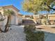 Neutral stucco single story with desert landscaping and mature palm trees, with a tile roof at 11037 Hawk Valley Ave, Las Vegas, NV 89134