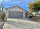 Gray double-car garage with a driveway and desert landscaping at 11037 Hawk Valley Ave, Las Vegas, NV 89134