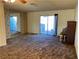 Living room with brown carpet, sliding glass door, and piano at 427 E Barrett St, Henderson, NV 89011