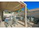 Covered patio with dining area, comfortable seating, and adjacent pool at 841 Glitter Glen Ct, Las Vegas, NV 89123