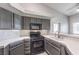 Kitchen with gray cabinets, white tile, and black appliances at 900 Heavenly Hills Ct # 217, Las Vegas, NV 89145