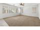 Large living room with ceiling fan and neutral carpet at 10929 Mount Royal Ave, Las Vegas, NV 89144